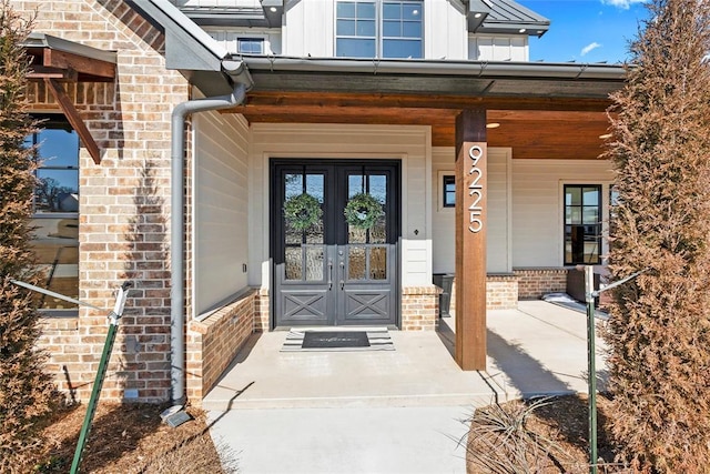 view of exterior entry featuring french doors and covered porch