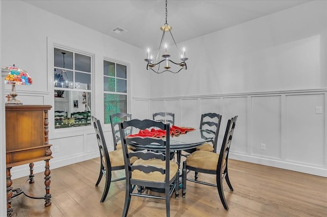 dining space featuring an inviting chandelier and light hardwood / wood-style floors