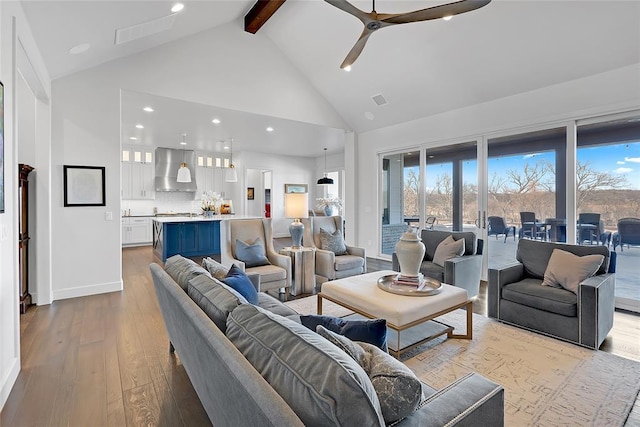 living room featuring beam ceiling, a wealth of natural light, high vaulted ceiling, and light wood-type flooring