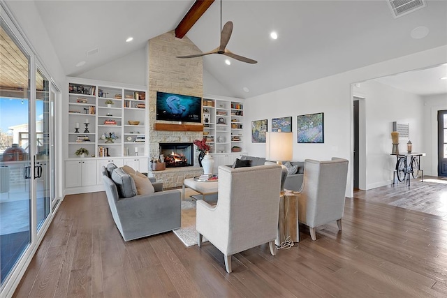 living room featuring hardwood / wood-style flooring, a stone fireplace, high vaulted ceiling, and beam ceiling