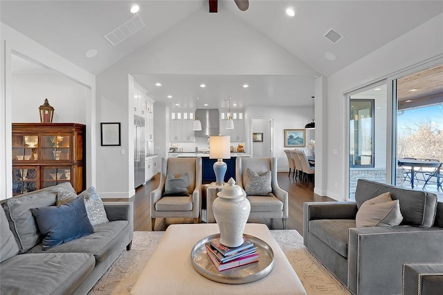 living room featuring beam ceiling, high vaulted ceiling, and light hardwood / wood-style floors