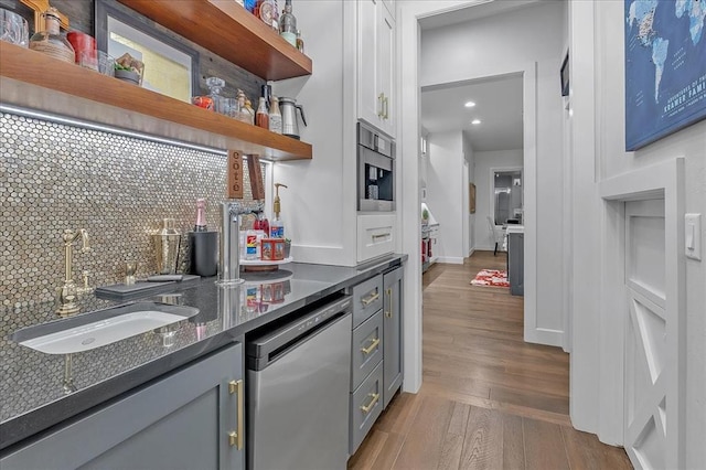 kitchen featuring gray cabinetry, sink, dishwasher, and light wood-type flooring