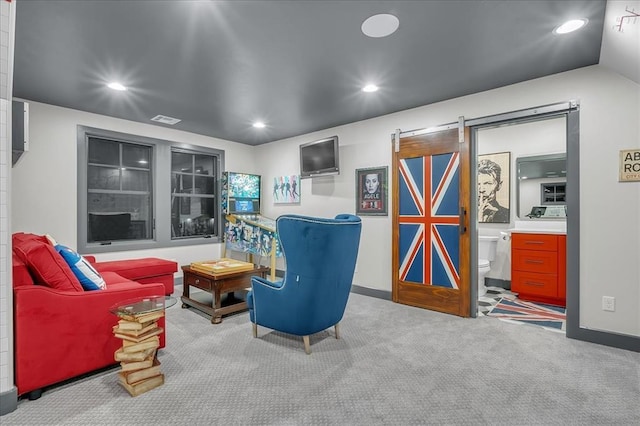 sitting room with carpet flooring and a barn door