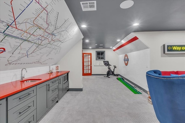 interior space with sink, gray cabinetry, tasteful backsplash, vaulted ceiling, and light carpet