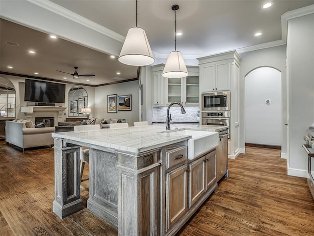 kitchen with white cabinetry, sink, ceiling fan, dark hardwood / wood-style floors, and a kitchen island with sink