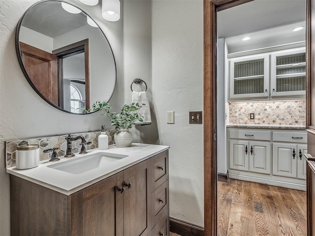 bathroom with backsplash, hardwood / wood-style floors, and vanity