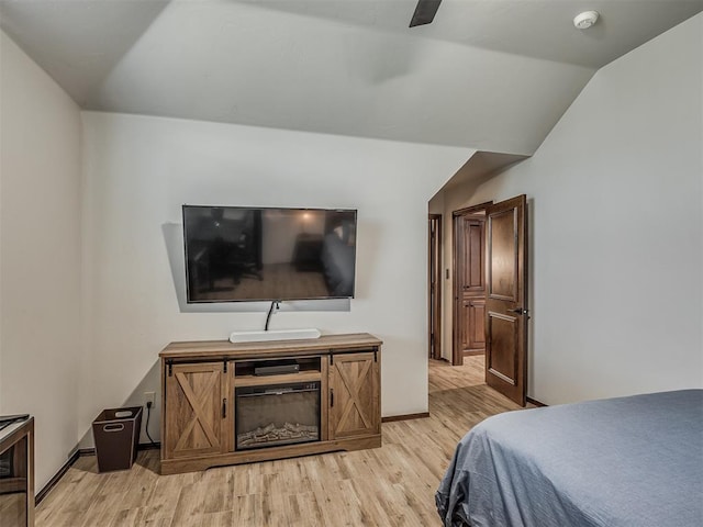 bedroom with ceiling fan, light hardwood / wood-style floors, and lofted ceiling