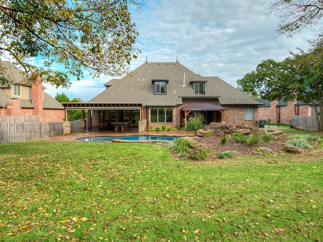 rear view of property featuring a pool with hot tub, a patio area, and a yard