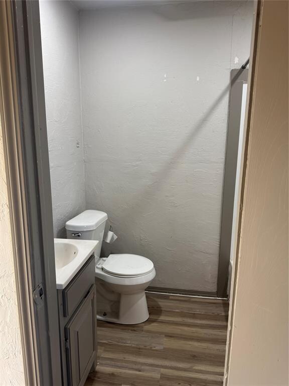 bathroom featuring wood-type flooring, vanity, and toilet