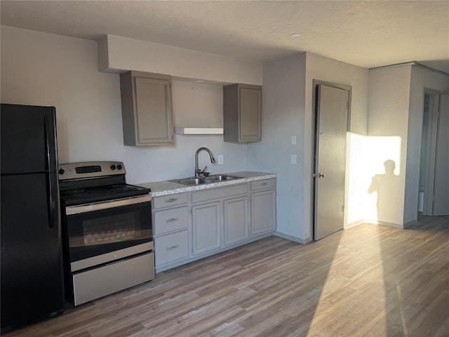 701 N Park Ln, Altus, OK 73521 - kitchen with freestanding refrigerator, a sink, electric range, gray cabinetry, and a textured ceiling