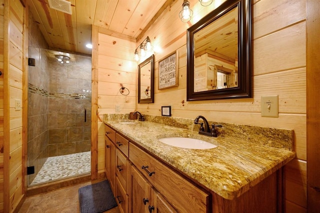 bathroom with vanity, wooden ceiling, wooden walls, tile patterned flooring, and walk in shower