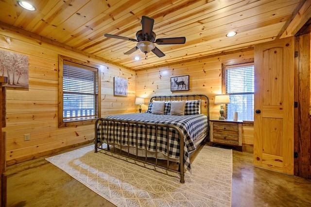 bedroom with ceiling fan, wood walls, wooden ceiling, and concrete floors