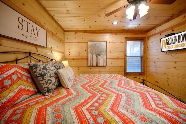 bedroom with ceiling fan, wood walls, and wooden ceiling