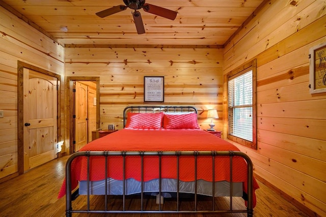 bedroom featuring hardwood / wood-style flooring, ceiling fan, wooden ceiling, and wood walls