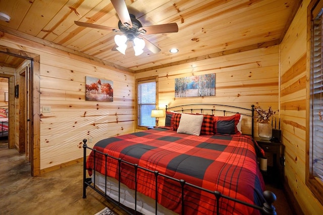 bedroom featuring concrete floors, wooden ceiling, ceiling fan, and wooden walls