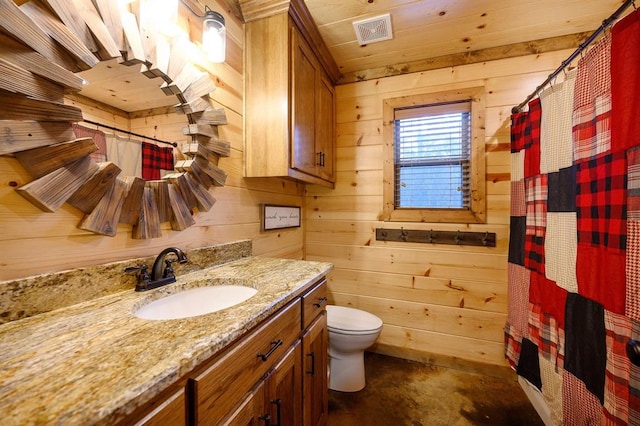 bathroom with vanity, toilet, concrete flooring, and wooden walls