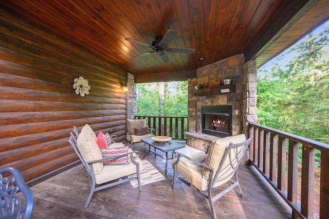 wooden terrace featuring ceiling fan and an outdoor stone fireplace