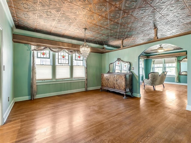 unfurnished bedroom featuring a chandelier, crown molding, and wood-type flooring