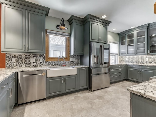 kitchen with plenty of natural light, gray cabinets, sink, and appliances with stainless steel finishes