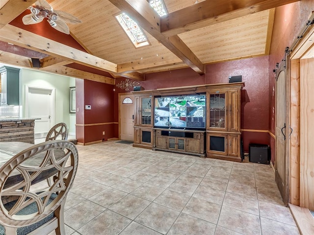 tiled living room with vaulted ceiling with skylight, ceiling fan, a barn door, and wooden ceiling