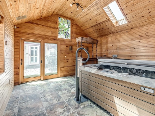 bedroom with a skylight, wooden walls, high vaulted ceiling, and wood ceiling