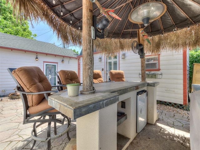 view of patio / terrace with area for grilling, a bar, and beverage cooler