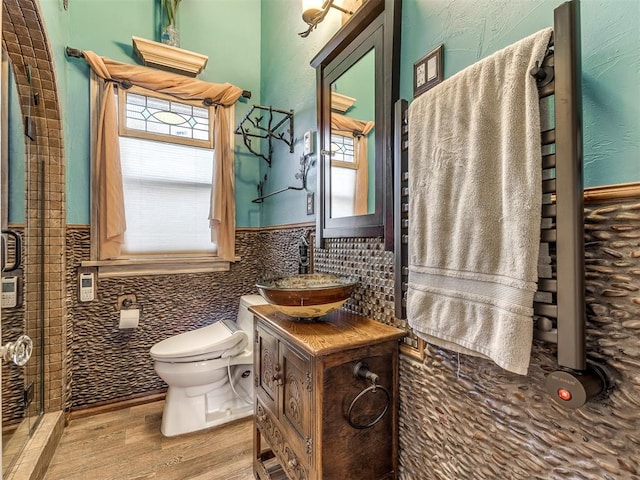 bathroom featuring hardwood / wood-style floors, vanity, toilet, and tile walls