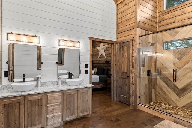 bathroom with wooden walls, a towering ceiling, an enclosed shower, and hardwood / wood-style flooring