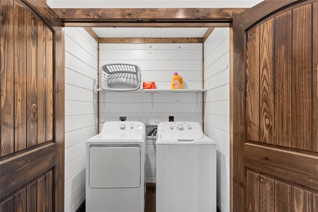 laundry area featuring washer and clothes dryer and wooden walls