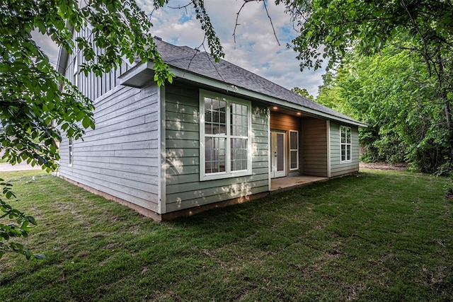 view of side of home featuring a patio area and a lawn