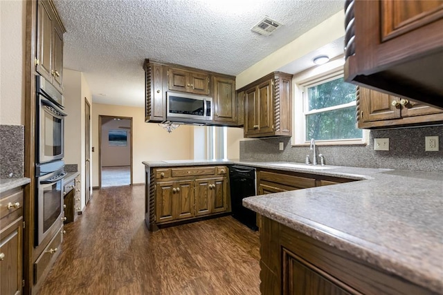 kitchen featuring kitchen peninsula, decorative backsplash, stainless steel appliances, dark wood-type flooring, and sink