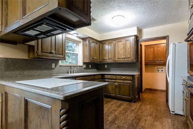 kitchen with dark hardwood / wood-style flooring, custom exhaust hood, white appliances, a textured ceiling, and sink