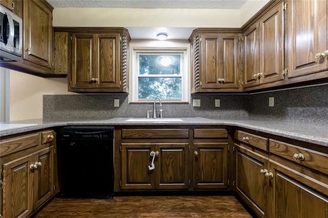 kitchen with black dishwasher, tasteful backsplash, stainless steel microwave, and sink