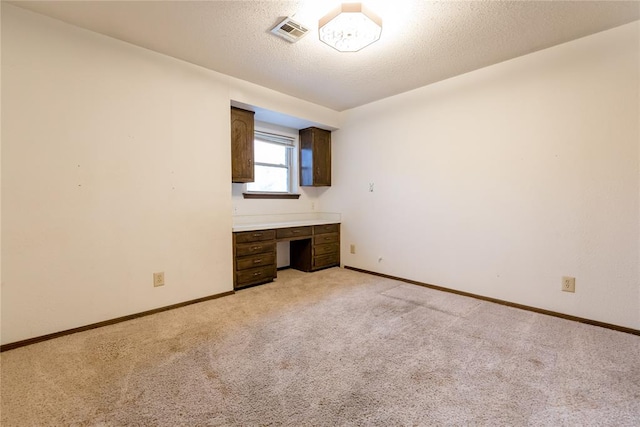 unfurnished bedroom with light carpet and a textured ceiling