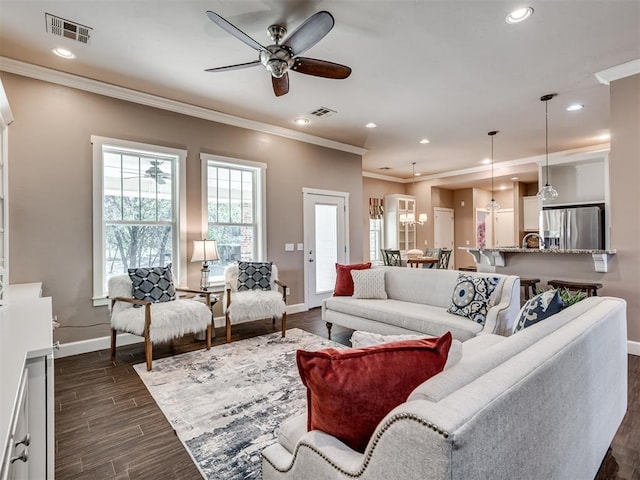 living room with ceiling fan, dark hardwood / wood-style flooring, and crown molding