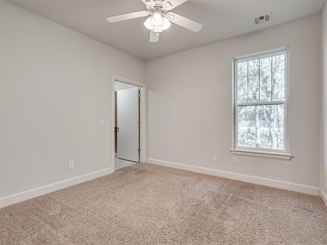 carpeted spare room featuring ceiling fan