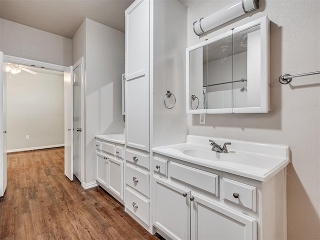 bathroom with hardwood / wood-style floors, ceiling fan, and vanity