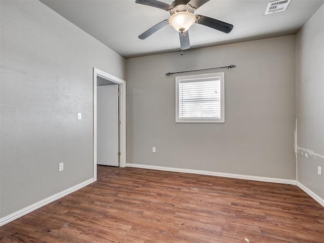 empty room featuring ceiling fan and dark hardwood / wood-style flooring