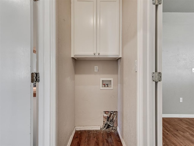 clothes washing area featuring washer hookup, cabinets, and wood-type flooring