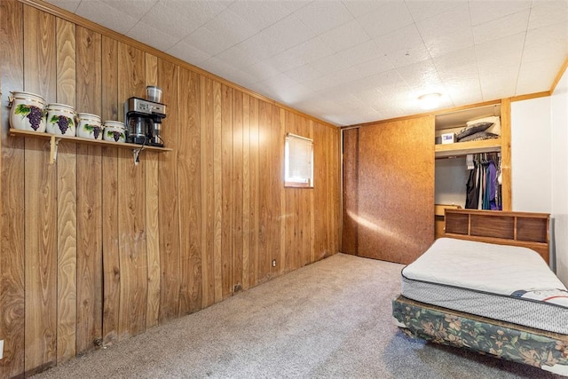 carpeted bedroom with crown molding and wood walls