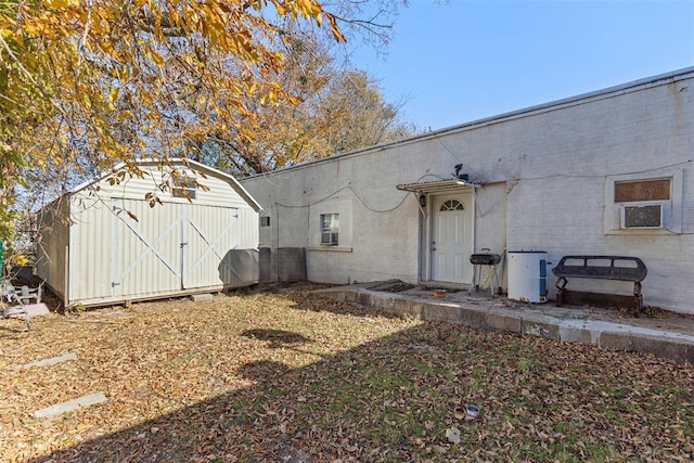 rear view of property with cooling unit and a shed