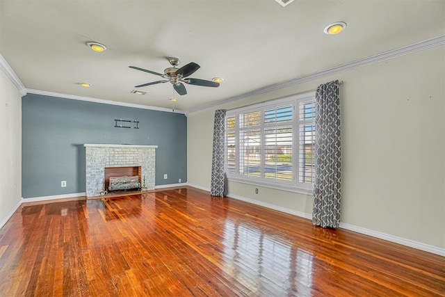 unfurnished living room with a brick fireplace, ceiling fan, ornamental molding, and hardwood / wood-style flooring