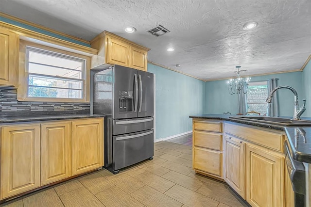 kitchen featuring sink, an inviting chandelier, tasteful backsplash, pendant lighting, and appliances with stainless steel finishes