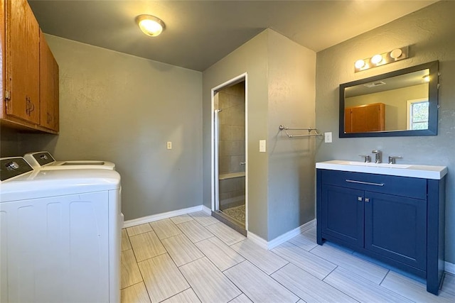 bathroom featuring vanity, a shower with shower door, and washing machine and clothes dryer