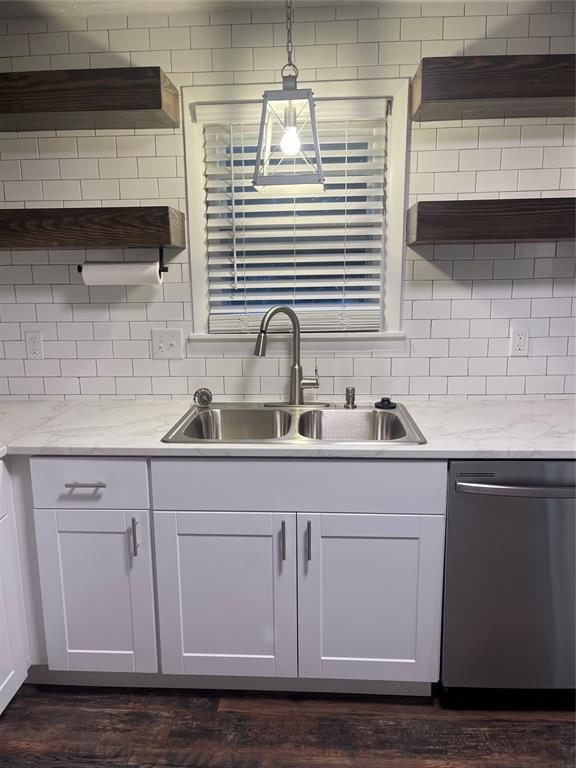 kitchen featuring white cabinetry, dishwasher, sink, backsplash, and decorative light fixtures