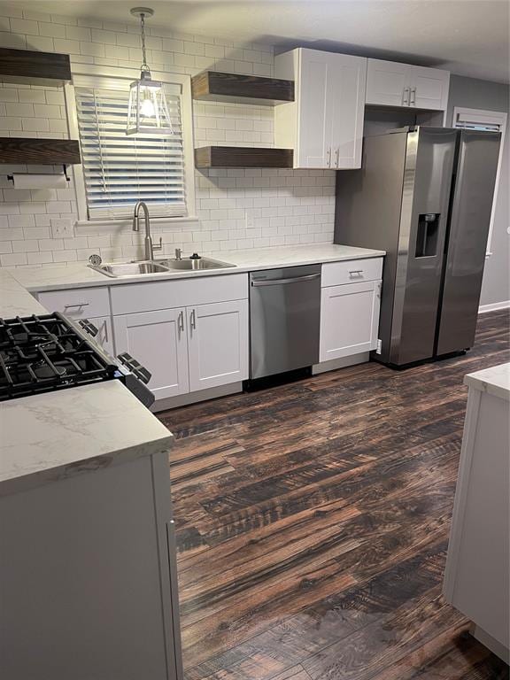 kitchen featuring white cabinets, hanging light fixtures, appliances with stainless steel finishes, and dark wood-type flooring