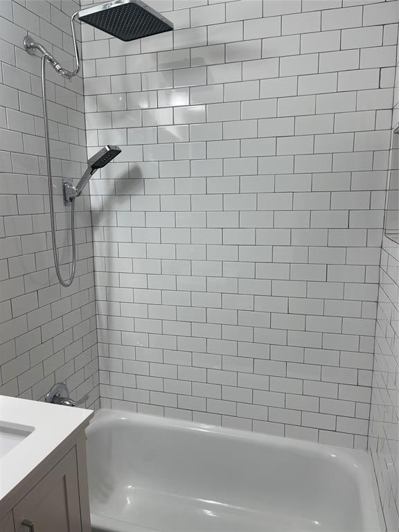 bathroom featuring vanity and tiled shower / bath