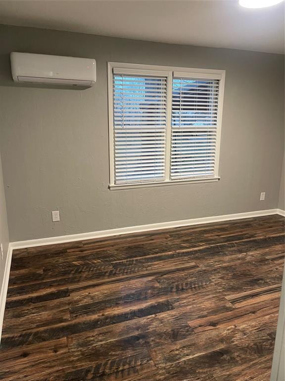 spare room with wood-type flooring and a wall unit AC