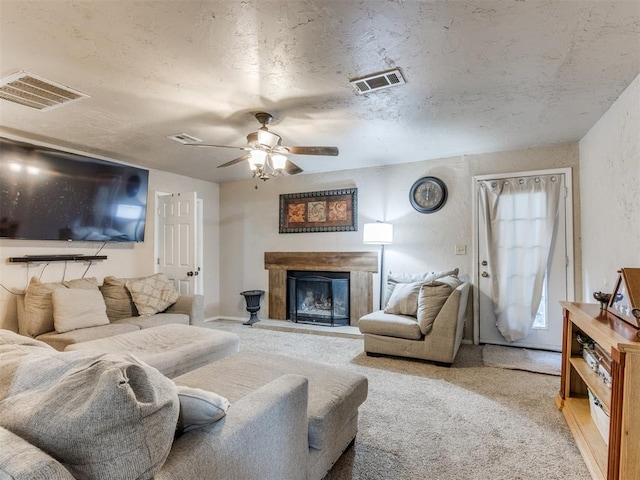 carpeted living room featuring a textured ceiling and ceiling fan