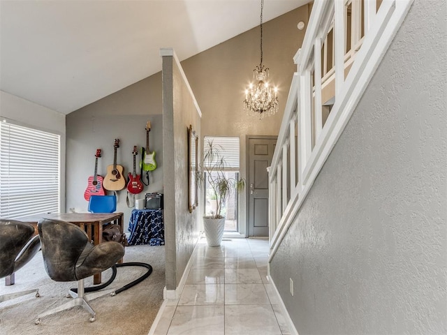 entrance foyer with high vaulted ceiling, a wealth of natural light, and a notable chandelier